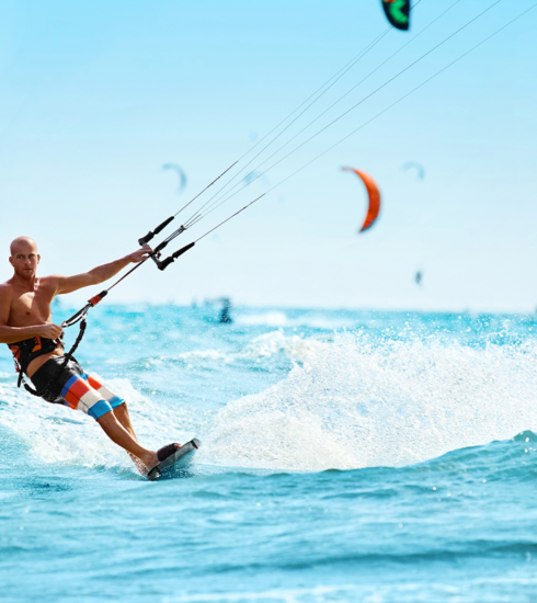 A surfer rides a wave at a beach.