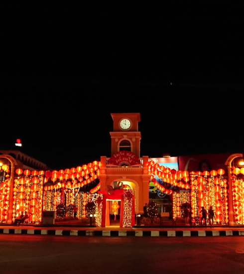 Phuket's vibrant Sino-Portuguese building illuminated at night, showcasing its colorful architecture against the evening sky.