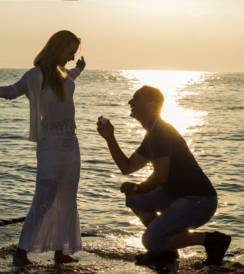 A man proposing to his partner at sunset on a romantic beach in Phuket, Thailand, with a stunning sea view.