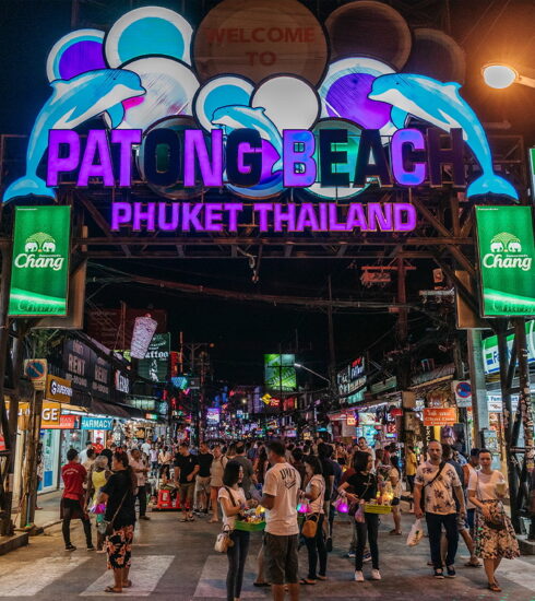 Lively Patong Beach nightlife scene with neon signs and people enjoying the bars.