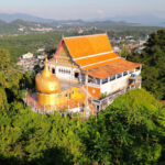 Aerial view of Wat Koh Sirey temple surrounded by lush greenery in Phuket, Thailand.